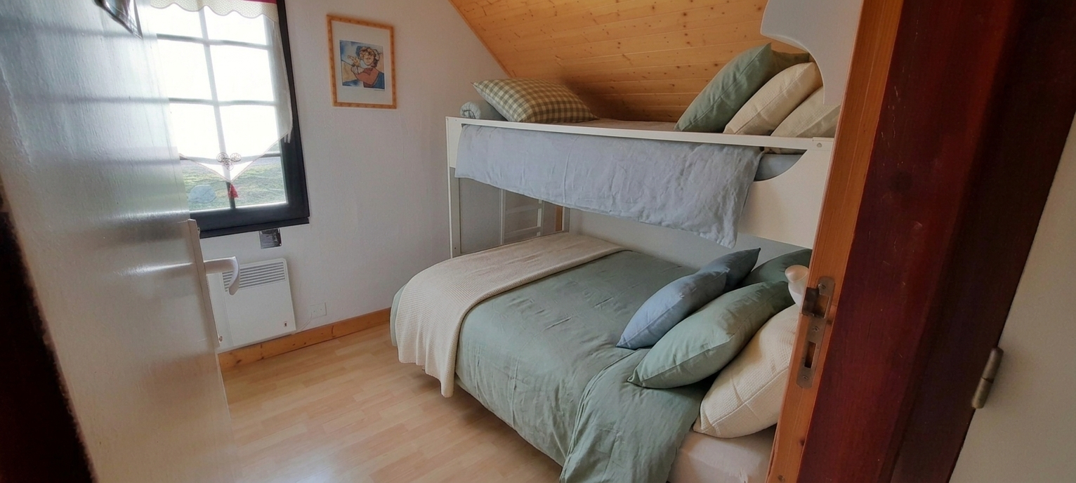 Chambre d'enfant avec lits superposés et vue montagne