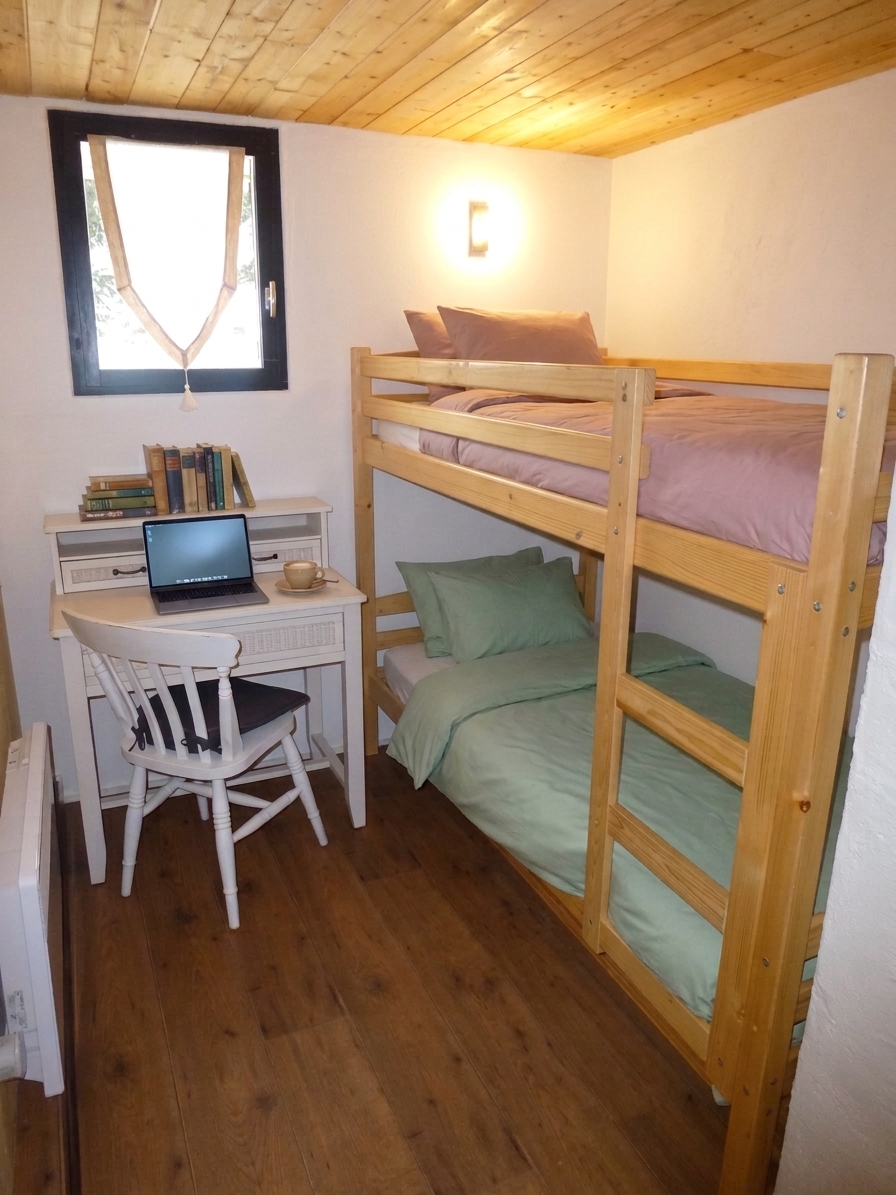 Chambre avec lits superposés, bureau et fenêtre